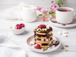 A sweet dessert of a chocolate cookie raspberry and marshmallow Cup of coffee on a light table.