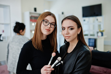 Make up artist work in her beauty visage studio salon. Woman applying by professional make up...