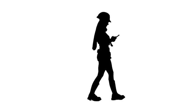 Builder girl with long hair in a helmet goes . Silhouette. White background . Side view
