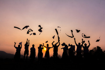 Fototapeta na wymiar Silhouette of cheering young generation Stand on the mountain at sunset.,Business concept idea