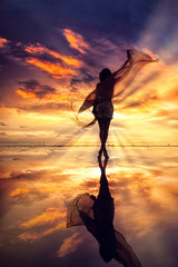 Silhouette of a Beautiful Woman at the beach in Thailand at sunset