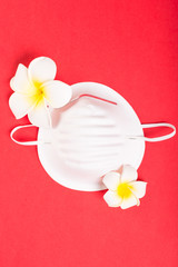 One face mask on pink background with exotic flowers.