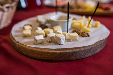 Camembert cheese cut into pieces on a wooden stand