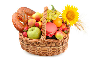 A set of fruits and pastries in a woven basket isolated on white background.