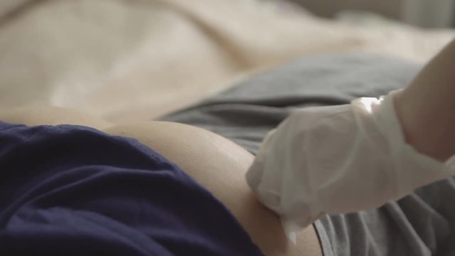 Woman injects with a syringe into the buttocks of a man.