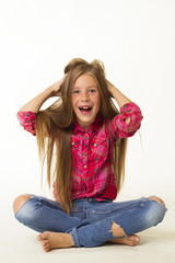 Young beautiful little girl smiles holding her hair over white background