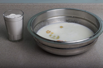 broken chicken eggs in a plate with milk and spices. Making an omlet.