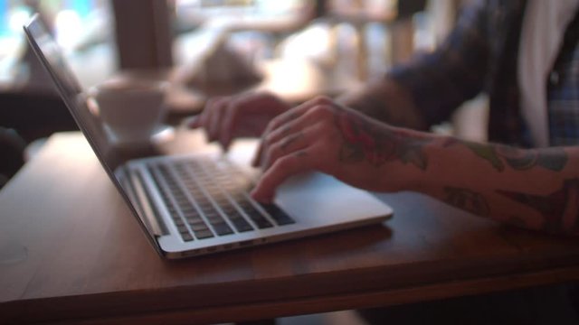 Cool enterpreneur working on his laptop in coffee shop