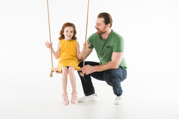 Father with happy daughter on swing isolated on white