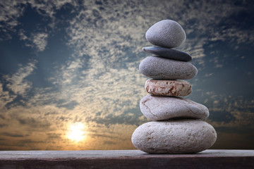 Balance Stones stacked to pyramid in the sunset sky background.