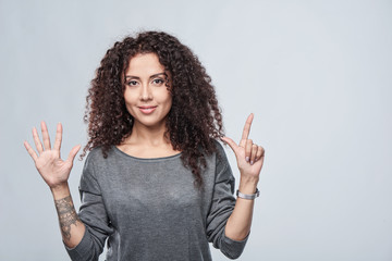 Hand counting - seven fingers. Smiling woman showing seven fingers