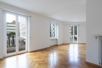 Empty room in a apartment with white walls and wooden floors