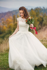 Fototapeta na wymiar Beauty woman, bride with perfect white dress posing in mountains