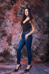 Beautiful Curvy woman Posing in Black Shirt and Jeans on multi-colored background. Plus size model test