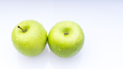 Closeup of green apple with water drops on white background. Selective focus.