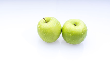 Closeup of green apple with water drops on white background. Selective focus.