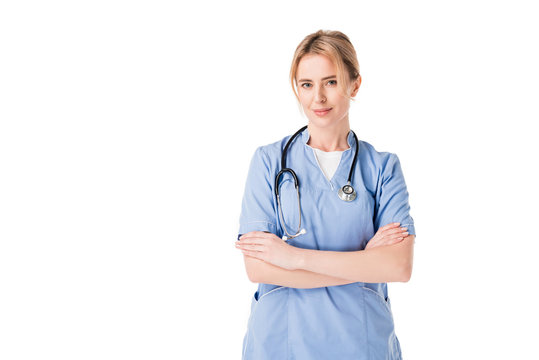 Female nurse in uniform with stethoscopes standing with arms folded isolated on white