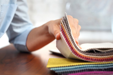 Tkaniny tapicerskie. Kobieta ogląda kolory i wzory tkanin obiciowych.