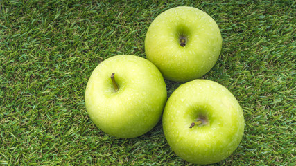Closeup of green apple with water drops on white background. Selective focus.