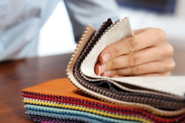 Tkaniny obiciowe. Kobieta ogląda kolory i wzory tkanin obiciowych.