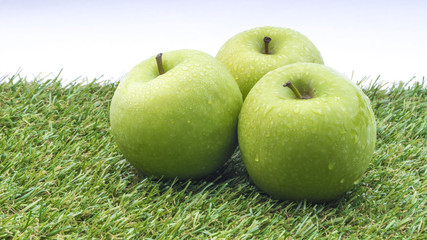 Closeup of green apple with water drops on white background. Selective focus.