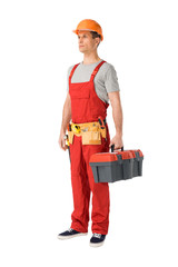 Handsome builder in uniform with tool belt holding toolbox isolated on white