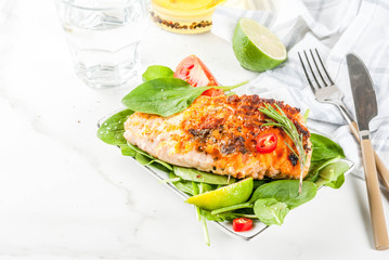 Grilled salmon steak filet with fresh vegetables, spinach and lime, white marble table copy space