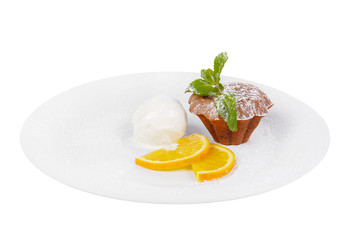 Chocolate cupcake, muffin on a white plate with orange slices, mint and vanilla ice cream isolated on white background. Dessert for a menu in a cafe, restaurant, coffee shop. side view