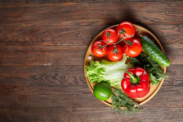 Close-up still life of assorted fresh vegetables and herbs on vintage wooden background, top view, selective focus.