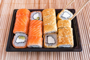 Philadelphia roll sushi with salmon, tuna, avocado, cream cheese and roll in the omelet. Sushi menu. Japanese food.