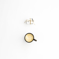 A cup of coffee and one small minimalist gift on a white background. Flat lay, top view
