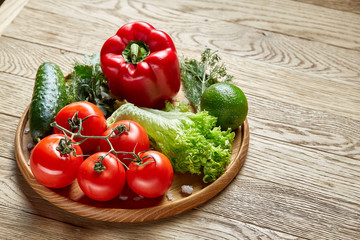 Close-up still life of assorted fresh vegetables and herbs on vintage wooden background, top view, selective focus.