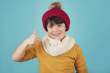 niño sonriente con bufanda y gorro en invierno