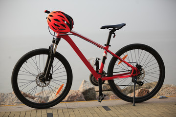 Naklejka premium red mountain bike and helmet on seaside