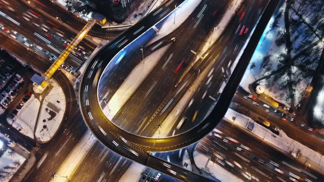 Aerial time-lapse night urban traffic scene, hyper-lapse evening Moscow traffic junction crossroad, intense transport highway load.