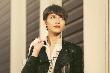 Happy young fashion woman in leather jacket with handbag