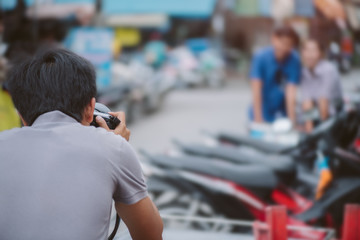 wedding photographer in action, wedding photographer takes pictures of the bride and groom in nature. Behind the scene of photography working concept.