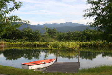 A orange and white boat on the lake