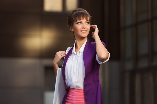 Young Fashion Business Woman In Purple Blazer With Handbag Walking At The Mall