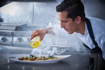 Chef preparing octopus in kitchen with smoke © lunamarina