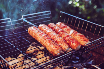 Grilling sausages on BBQ. Juicy beef. camping