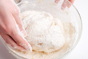 Making dough by female hands on white table