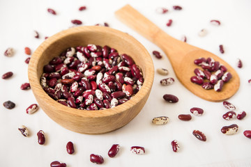 red kidney beans.wooden plate and spoon.white background.close-up view
