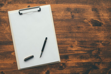 Overhead view of blank clipboard note pad paper with pen