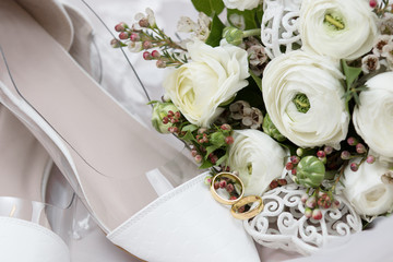 Beautiful wedding bouquet of white roses and shoes