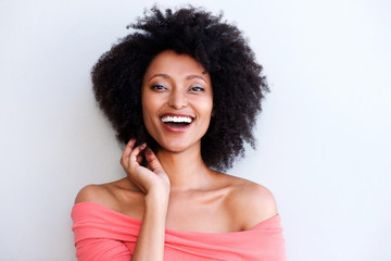 Close up young african woman with curly hair smiling against white background