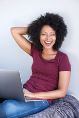 cheerful woman relaxing at home with laptop computer and laughing