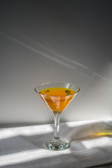 Orange drink with green leaves in a glass