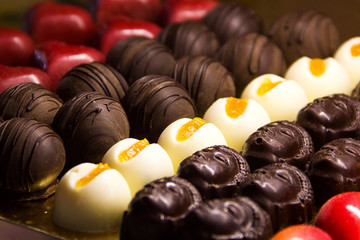 there are a lot of delicious macro chocolates on a gold tray in the storefront