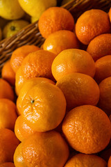 there are many orange yellow macro mandarins and lemons in wicker basket